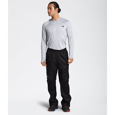 Man wearing a grey sweatshirt and black The North Face track pants.