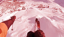 Load image into Gallery viewer, Orange/red filtered point of view of a person skiing down a slope
